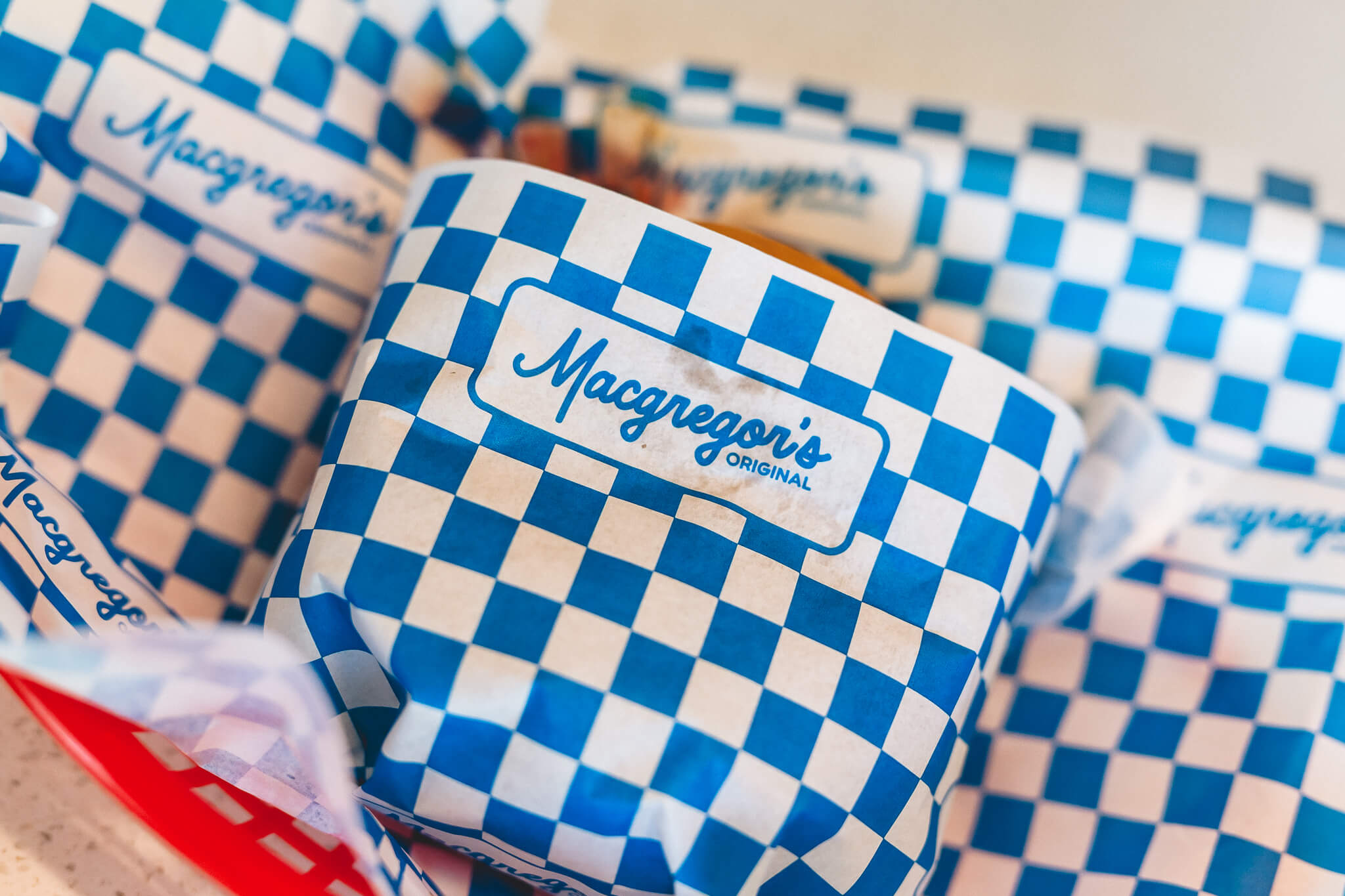 Burgers wrapped in Macgregor's blue-checkered branded paper.